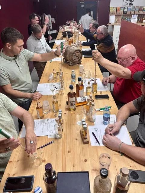 Atelier Créez votre whisky : les participants assemblent leur whisky à la pipette autour d'une longue table