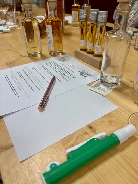 Table d'atelier : fiche de dégustation, stylo, échantillons de whisky et pipette