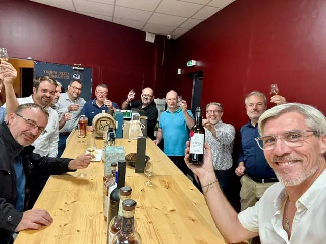 Participants à un atelier de dégustation qui trinquent autour de la grande table de La Cave Laurent